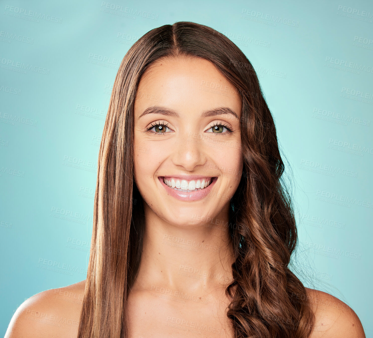 Buy stock photo Studio portrait of an attractive young woman posing against a blue background