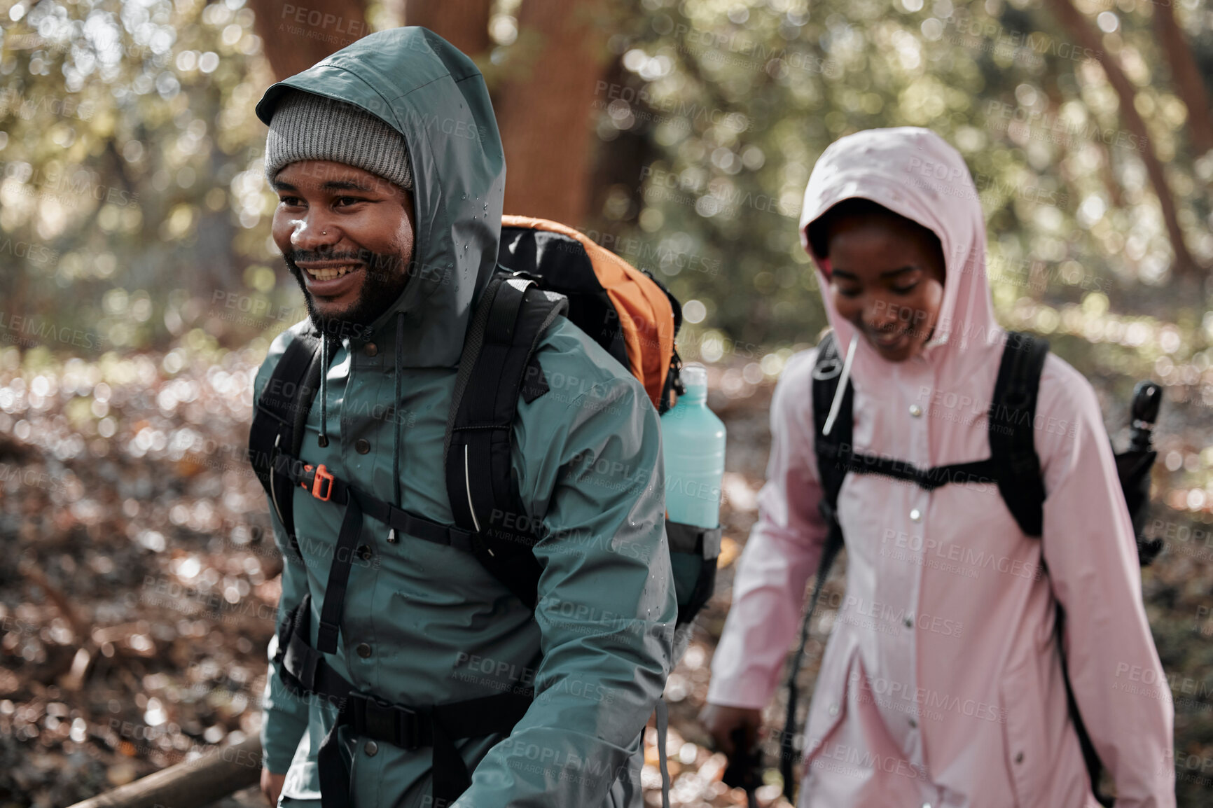 Buy stock photo Happy, black couple and hiking with smile for travel, adventure or journey together in nature. African man and woman hiker walking or trekking in tree forrest or woods with backpack in the outdoors