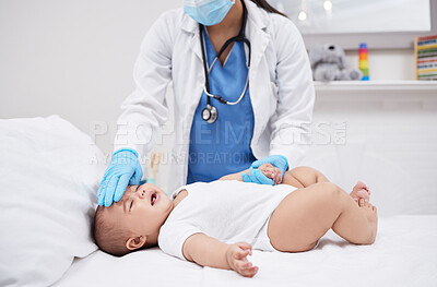 Buy stock photo Shot of a doctor feeling a baby's temperature in a hospital