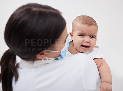 Buy stock photo Shot of a doctor holding a baby in a clinic