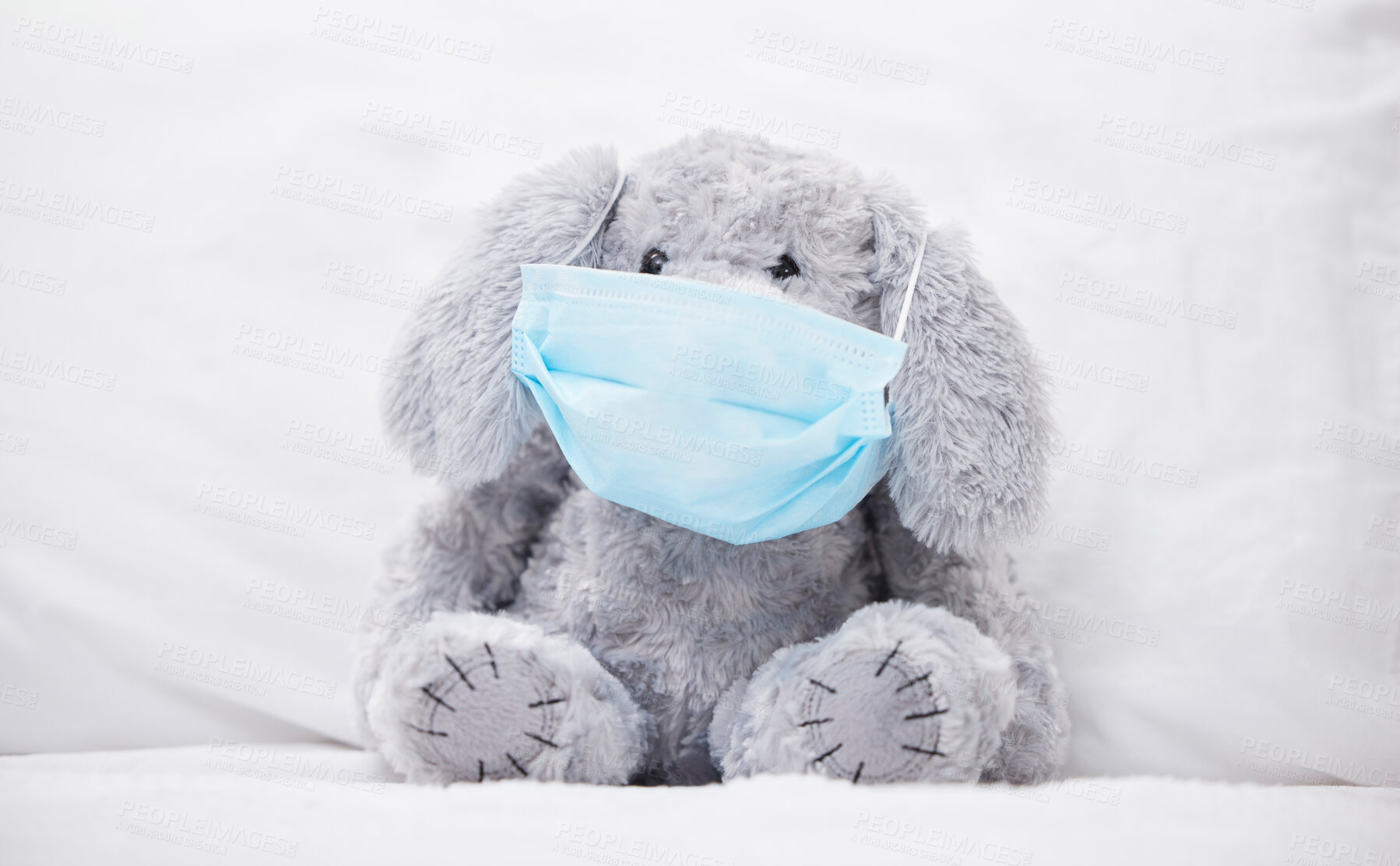 Buy stock photo Teddy bear, illness and mask in home with protection from virus or bacteria, wellness and healthcare. Toy animal, sick bunny and safety in bedroom for flu, contagious infection and medical problem