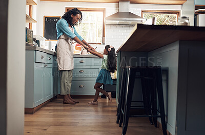 Buy stock photo Shot of a young woman dancing with her daughter in the kitchen at home