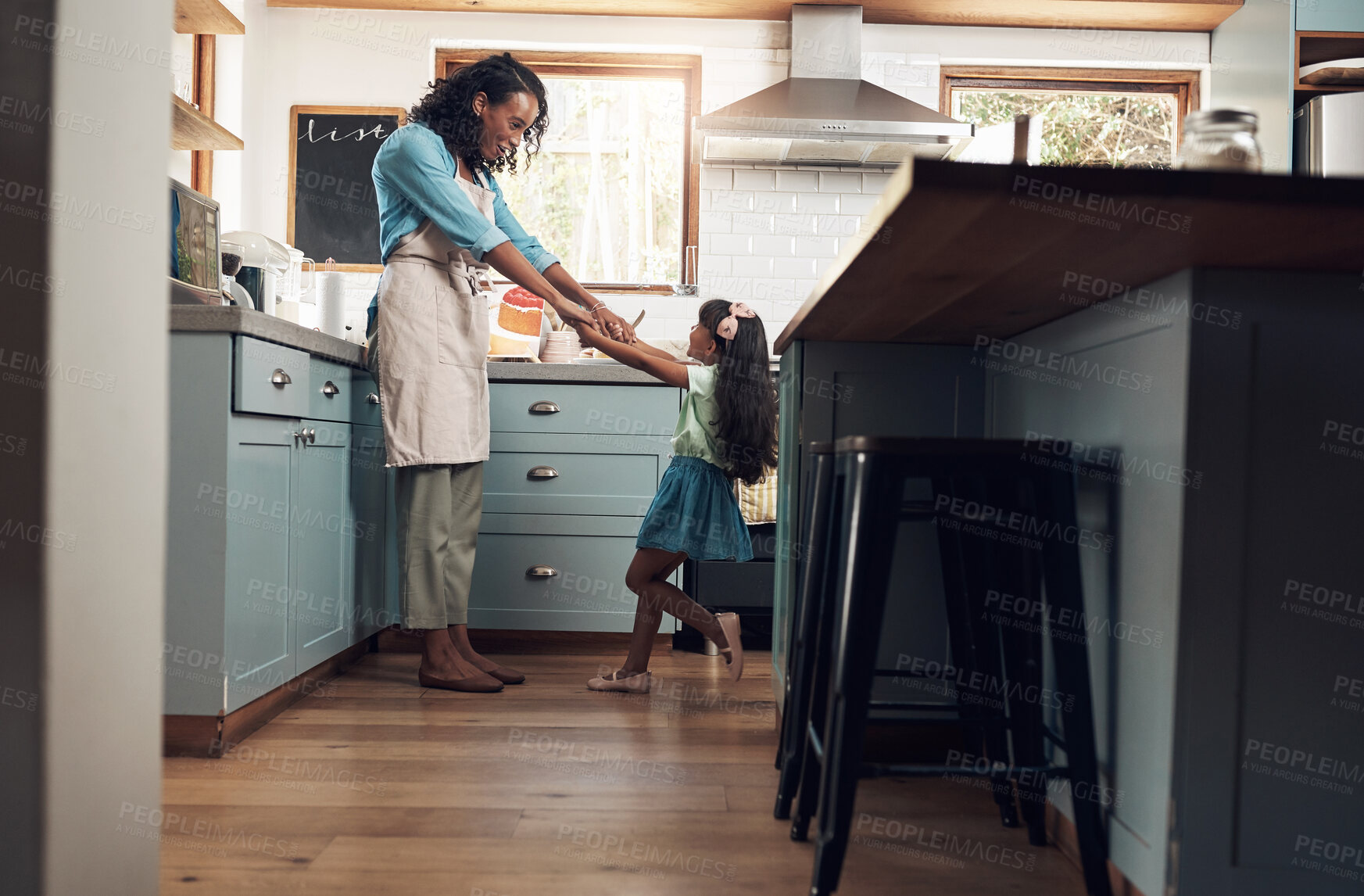 Buy stock photo Shot of a young woman dancing with her daughter in the kitchen at home