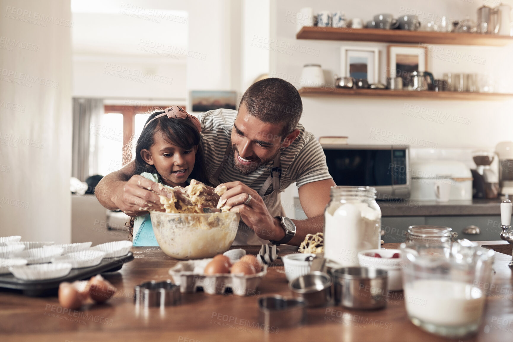 Buy stock photo Shot of a father teaching his daughter how to bake in the kitchen at home