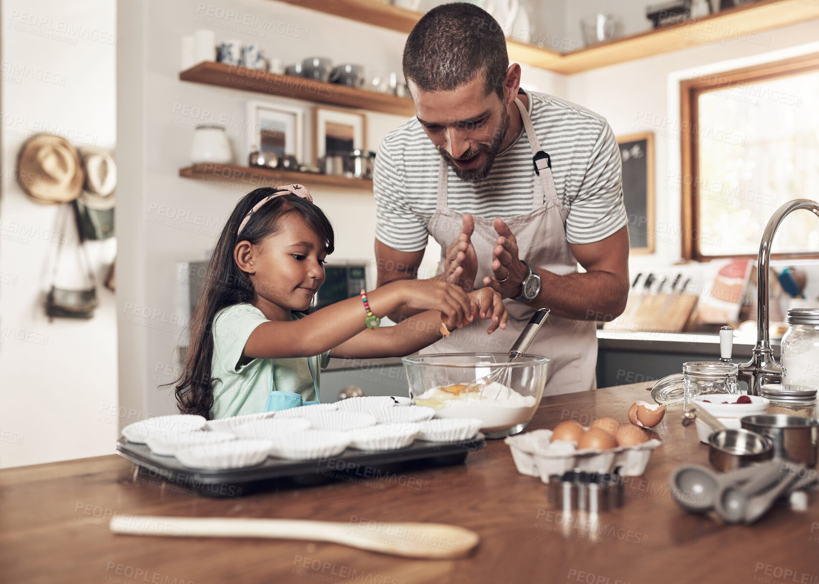 Buy stock photo Shot of a father teaching his daughter how to bake in the kitchen at home