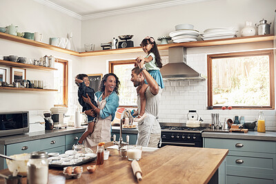 Buy stock photo Shot of a young family spending quality time together in the kitchen at home