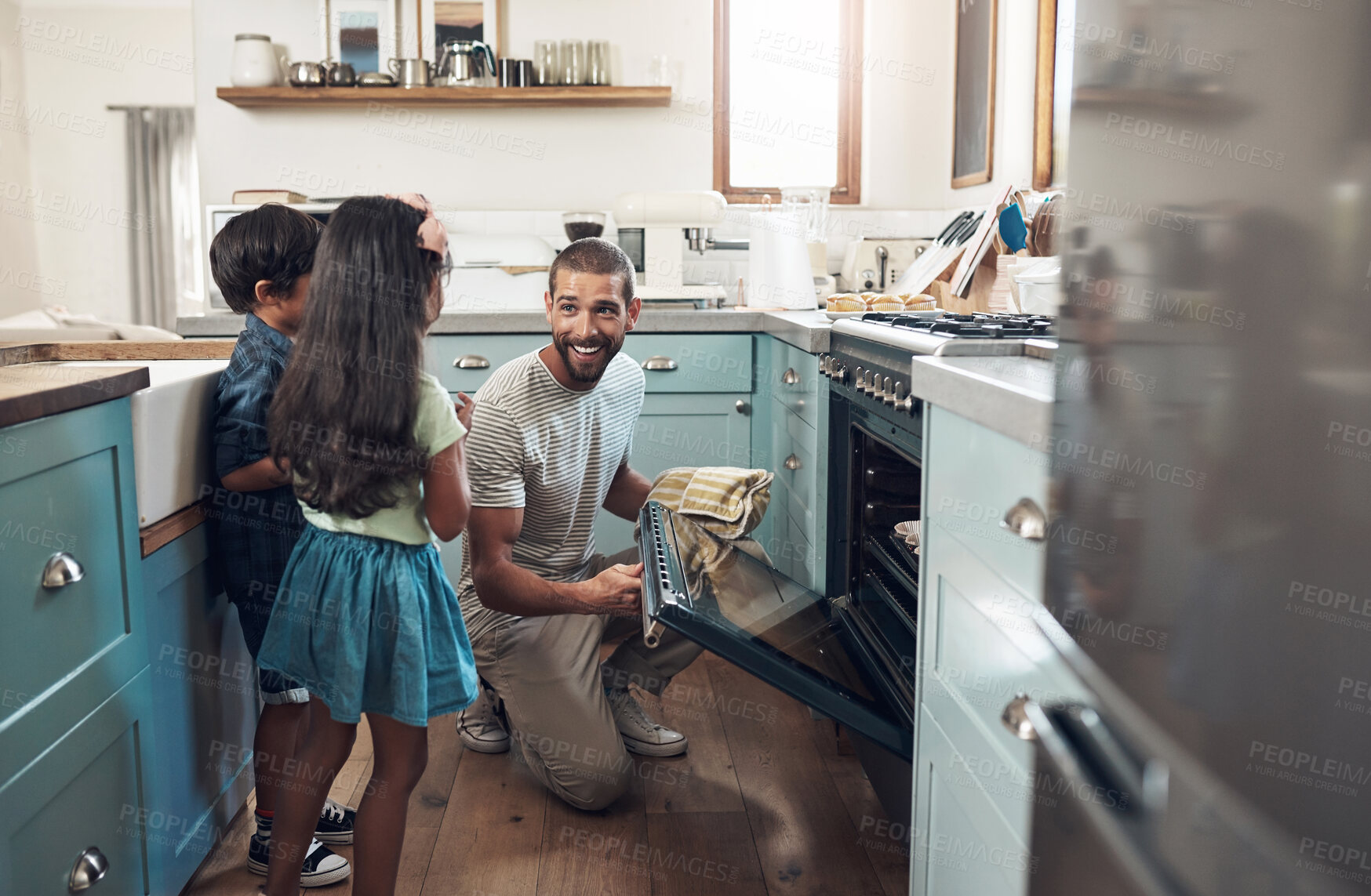 Buy stock photo Shot of a young man baking at home with his two young kids