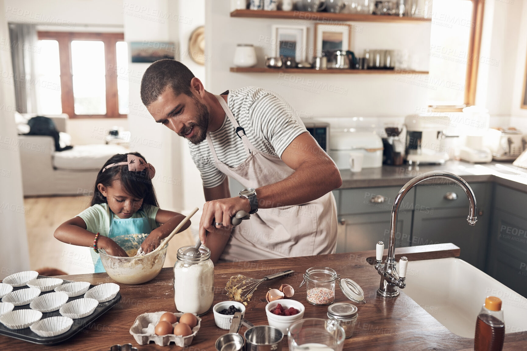 Buy stock photo Shot of a father teaching his daughter how to bake in the kitchen at home