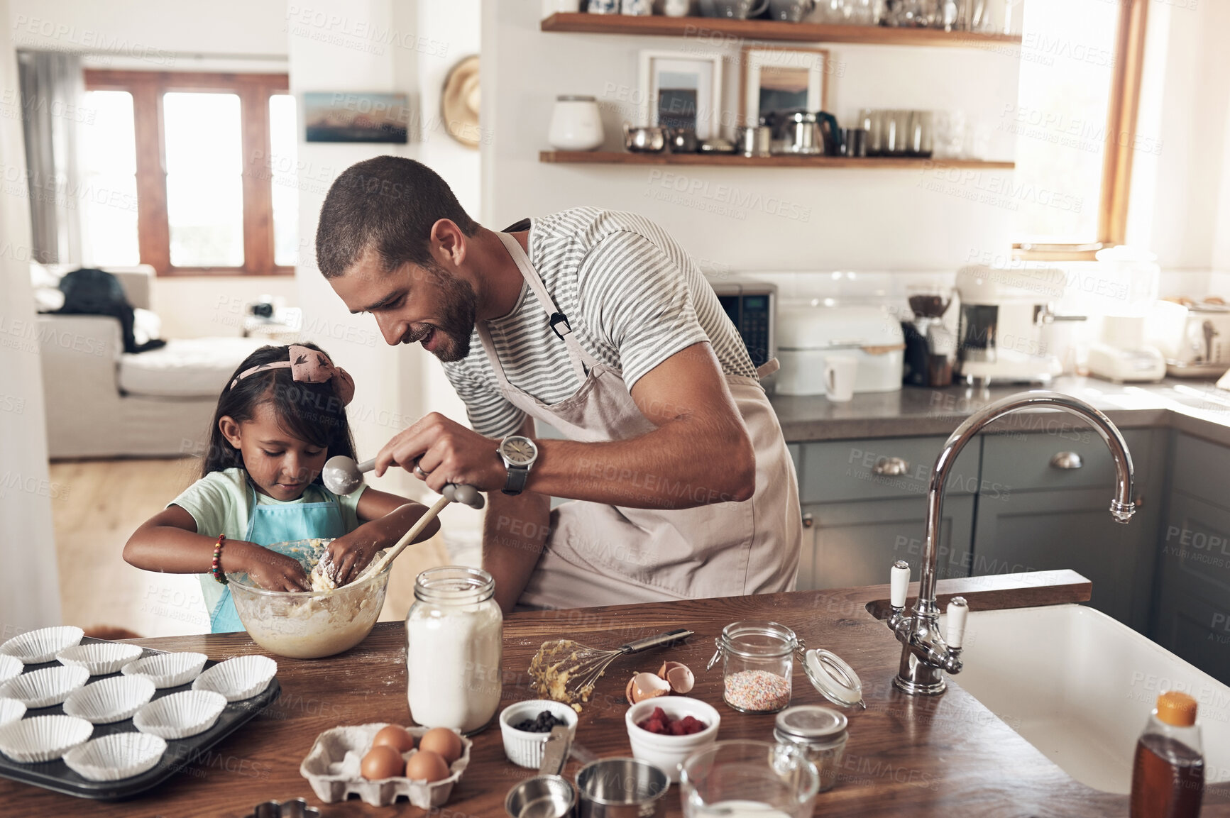 Buy stock photo Shot of a father teaching his daughter how to bake in the kitchen at home