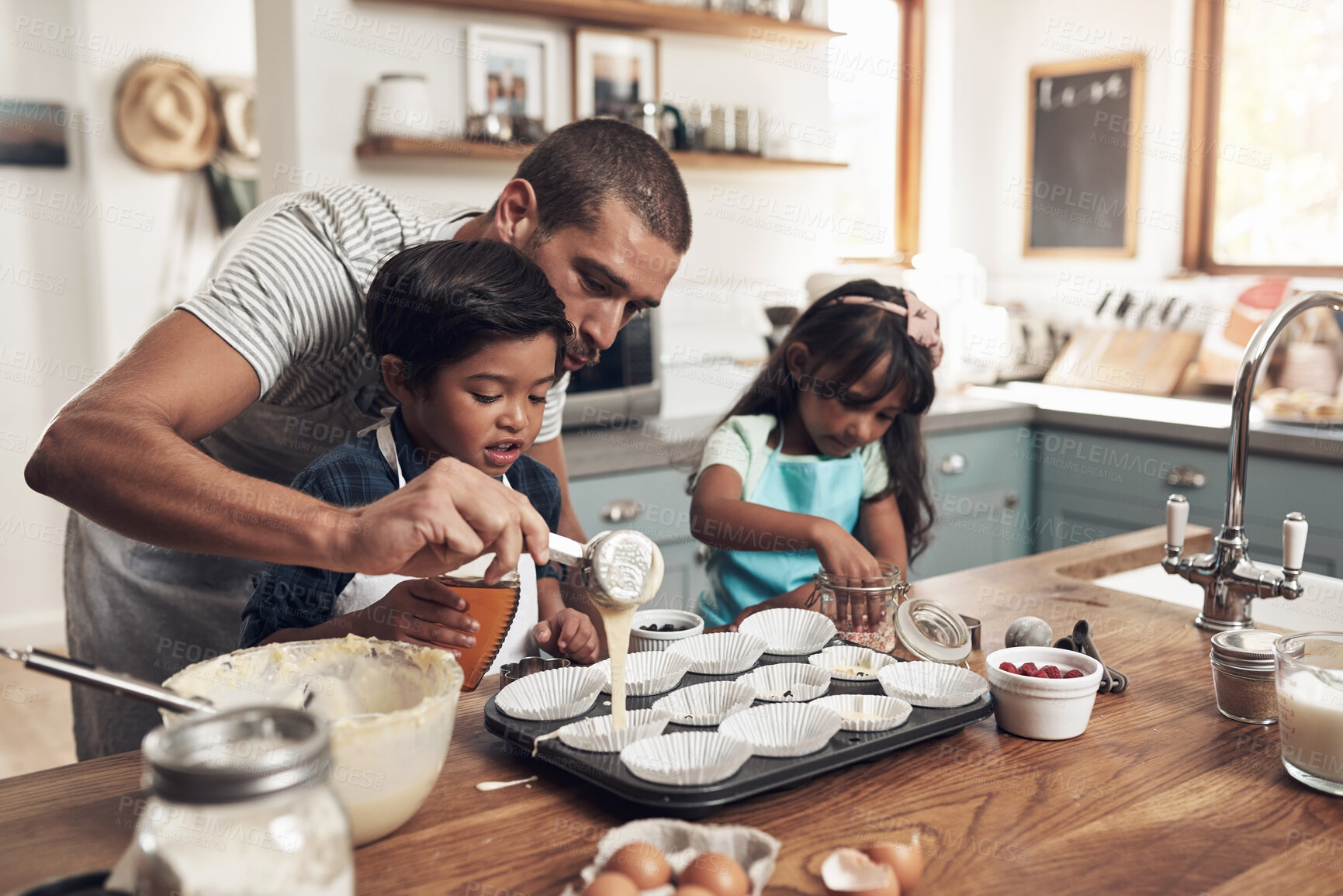 Buy stock photo Shot of a father teaching his children how to bake in the kitchen at home
