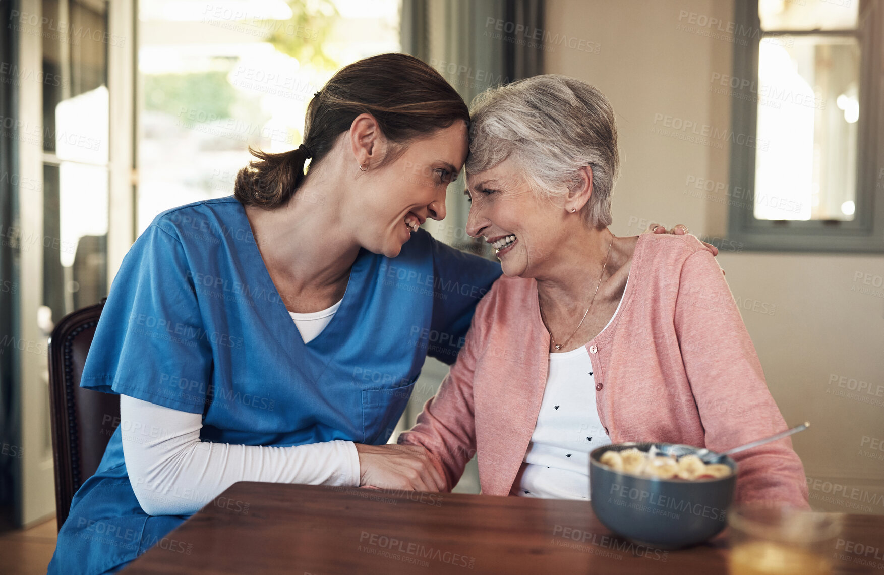 Buy stock photo Shot of a young nurse sitting with a senior woman at breakfast time in a nursing home