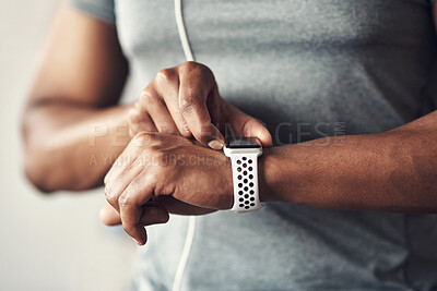 Buy stock photo Closeup shot of an unrecognisable man checking his wristwatch while exercising at home