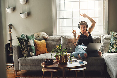 Buy stock photo Dancing, headphones and woman on sofa and laptop, happy energy and mental health music in her home. Young person on couch listening to audio tech, electronics and podcast on computer in living room