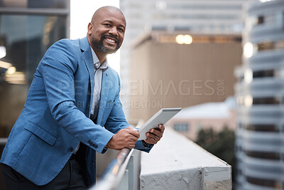 Buy stock photo Portrait of a mature businessman using a digital tablet while standing on a balcony outside an office