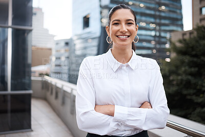 Buy stock photo Portrait of a confident young businesswoman standing with her arms crossed on a balcony outside an office