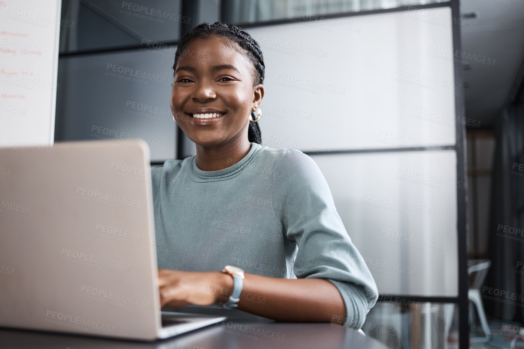 Buy stock photo Portrait of a young businesswoman working on a laptop in an office