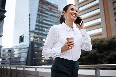 Buy stock photo Shot of a young businesswoman talking on a cellphone while drinking coffee outside an office