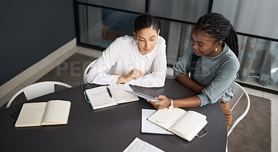 Buy stock photo Shot of two businesswomen working together on a digital tablet in an office