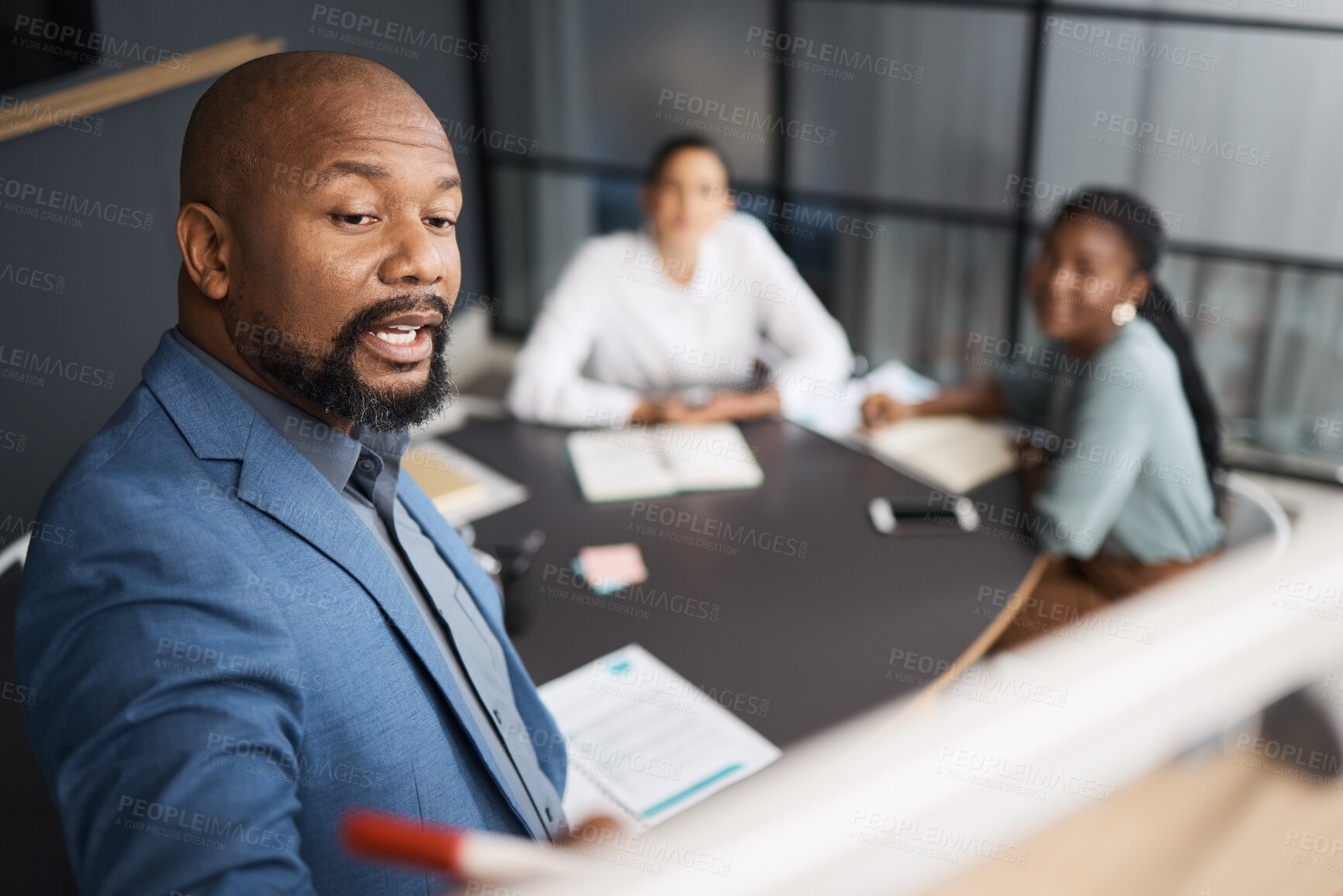 Buy stock photo Shot of a mature businessman using a whiteboard during a presentation to his colleagues in an office