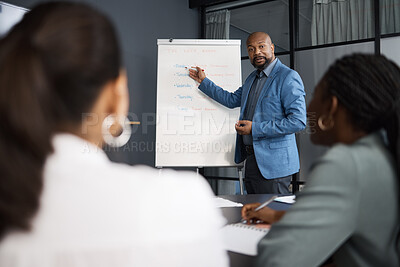 Buy stock photo Shot of a mature businessman using a whiteboard during a presentation to his colleagues in an office