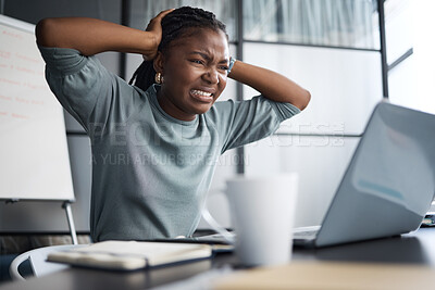 Buy stock photo Shot of a young businesswoman looking stressed out while using a laptop in an office