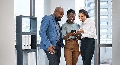 Buy stock photo Shot of a group of businesspeople using a cellphone together in an office