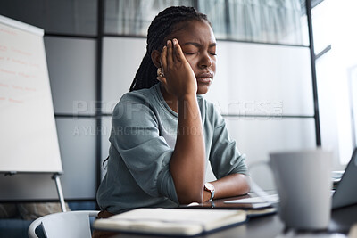 Buy stock photo Shot of a young businesswoman looking stressed out while working on a laptop in an office