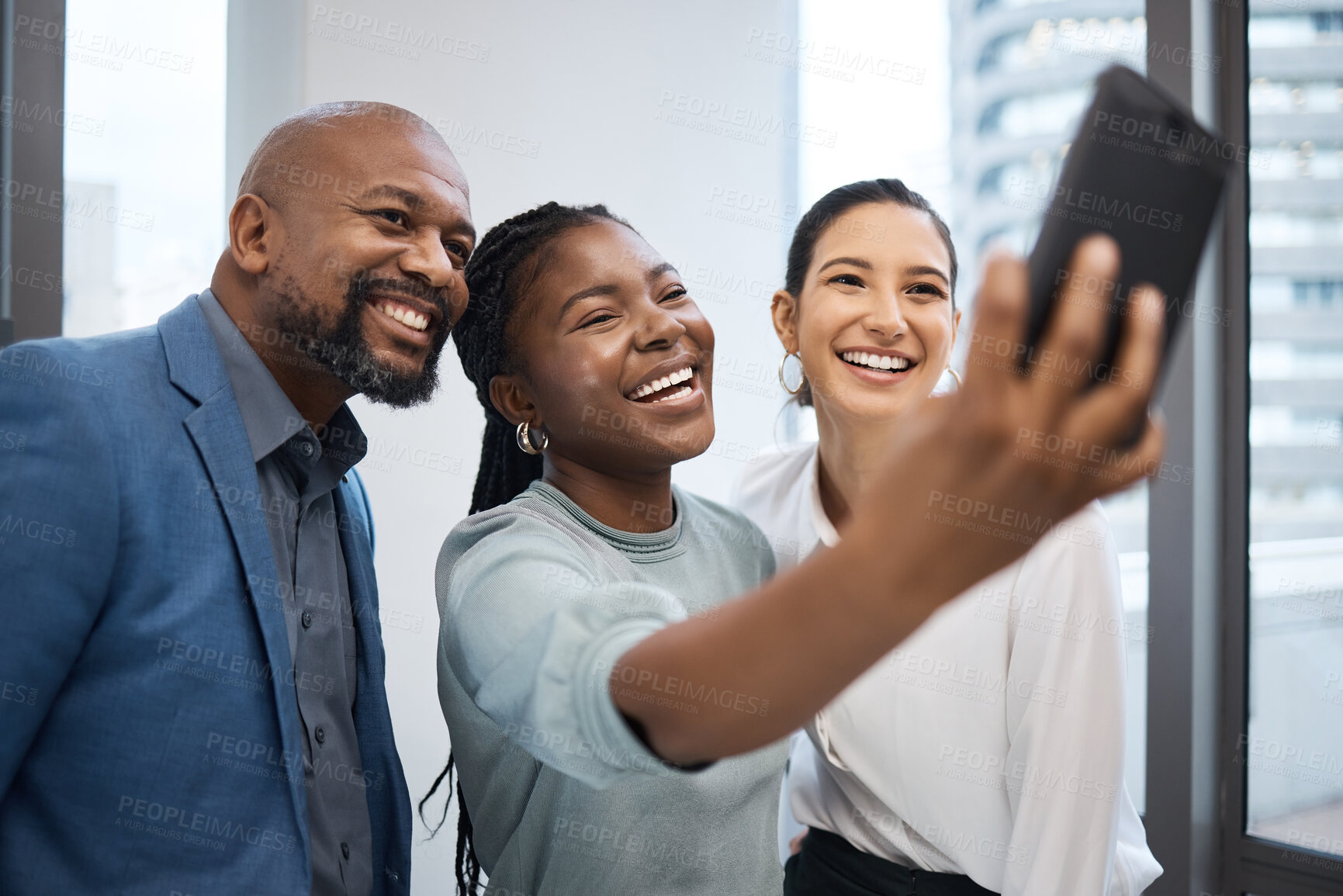 Buy stock photo Shot of a group of businesspeople taking selfies together in an office