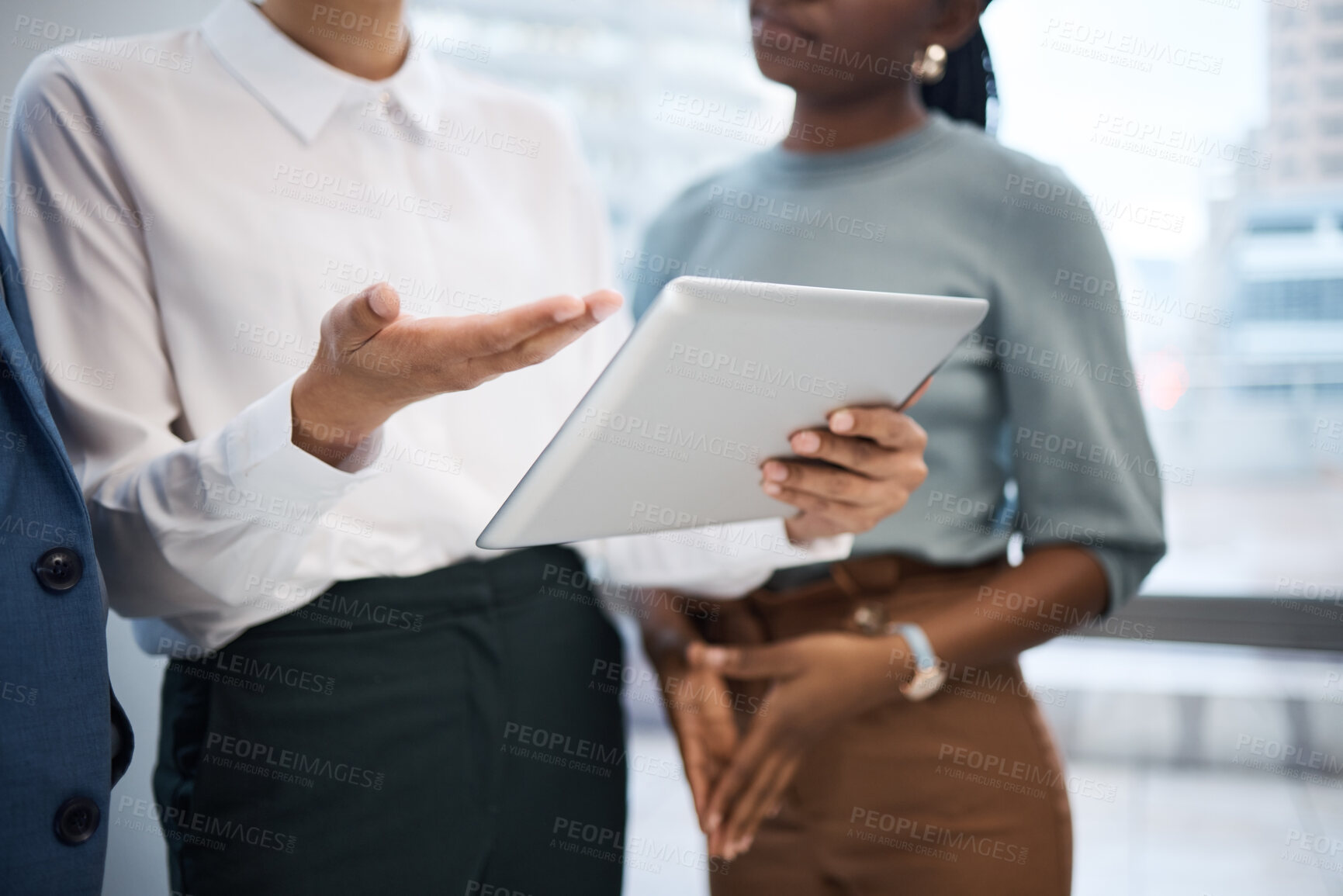 Buy stock photo Closeup shot of a group of unrecognisable businesspeople using a digital tablet together in an office