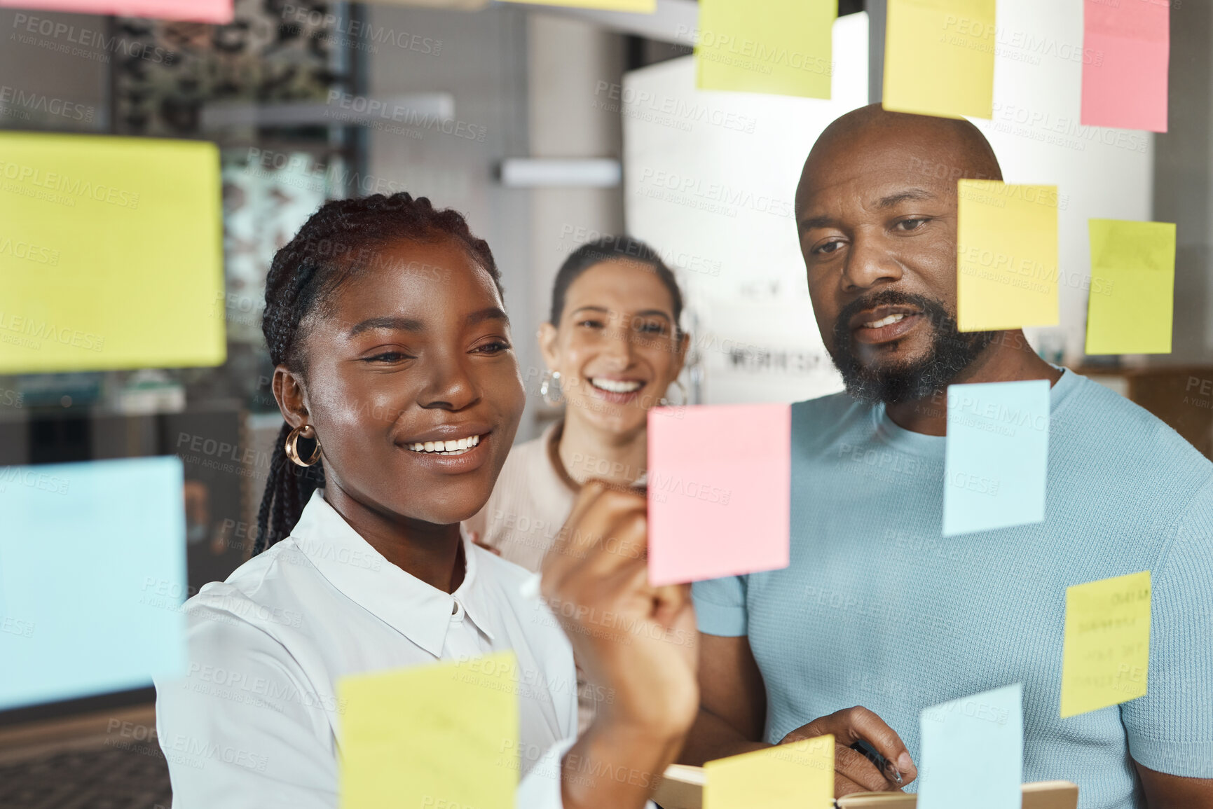 Buy stock photo Shot of a group of businesspeople brainstorming with sticky notes on a glass screen