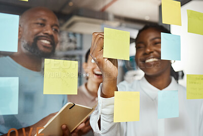 Buy stock photo Shot of a group of businesspeople brainstorming with sticky notes on a glass screen