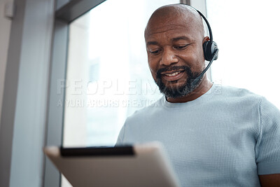 Buy stock photo Shot of a man using a digital tablet while working in a call center