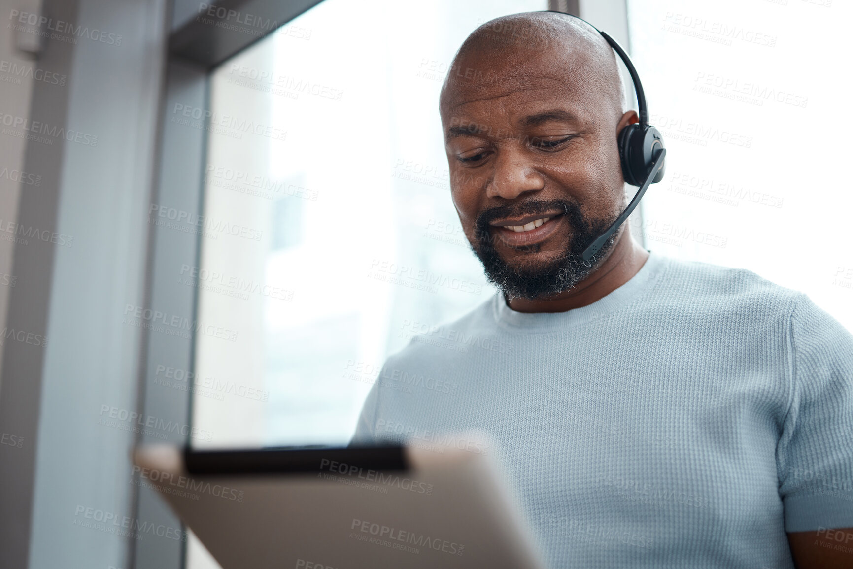 Buy stock photo Shot of a man using a digital tablet while working in a call center