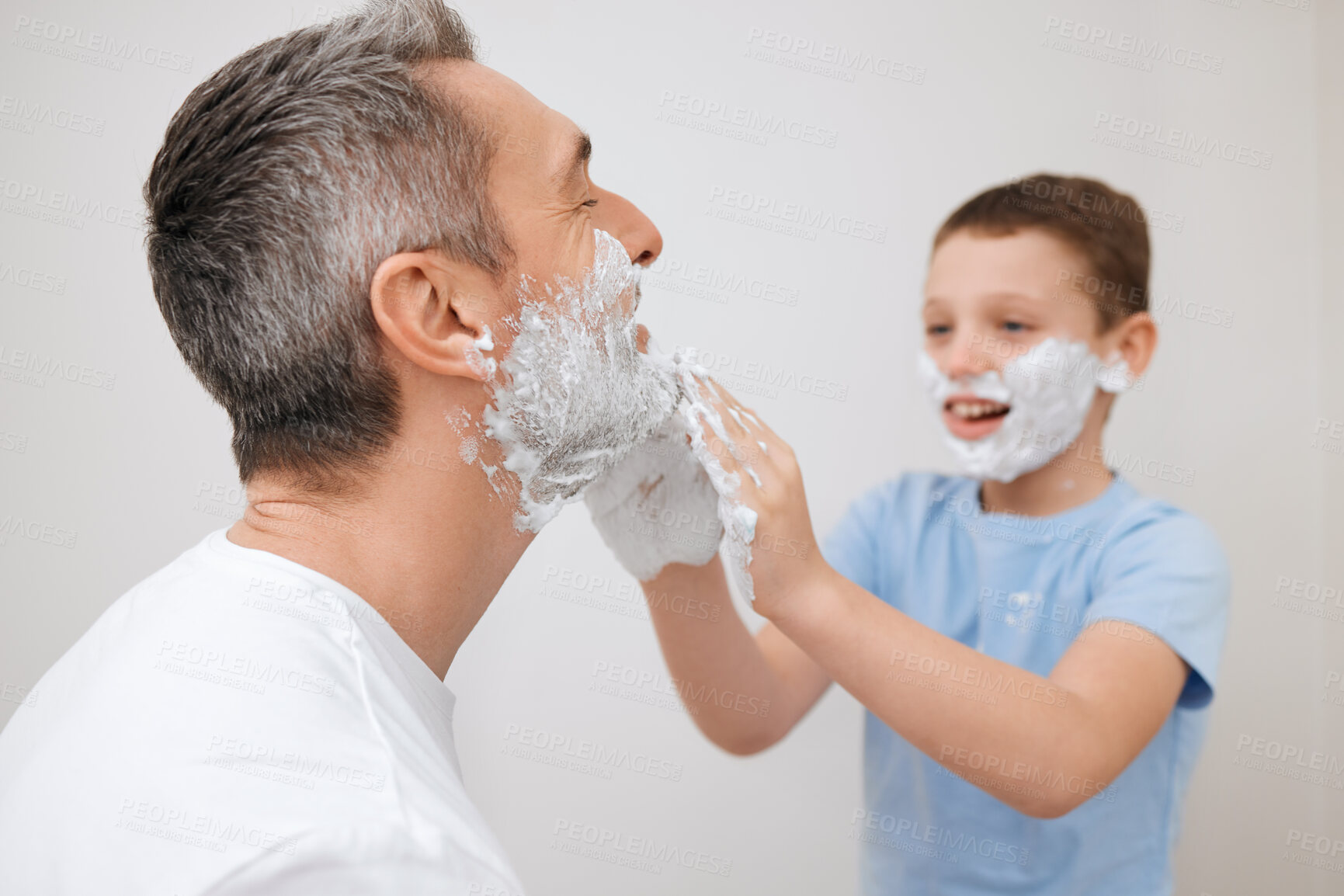 Buy stock photo Cropped shot of a handsome mature man teaching his young son how to shave in the bathroom at home