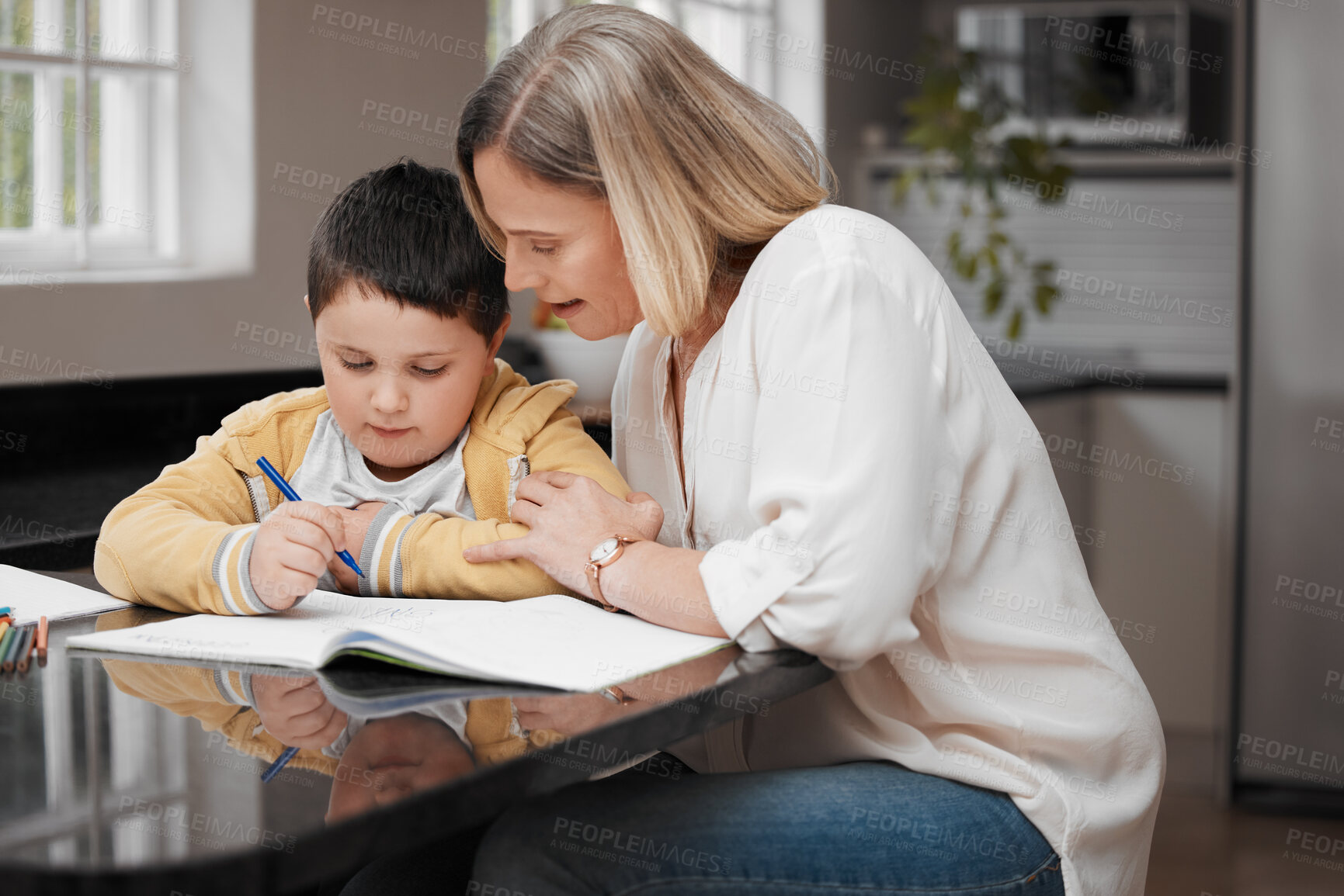 Buy stock photo Shot of a beautiful mother helping her son with his homework