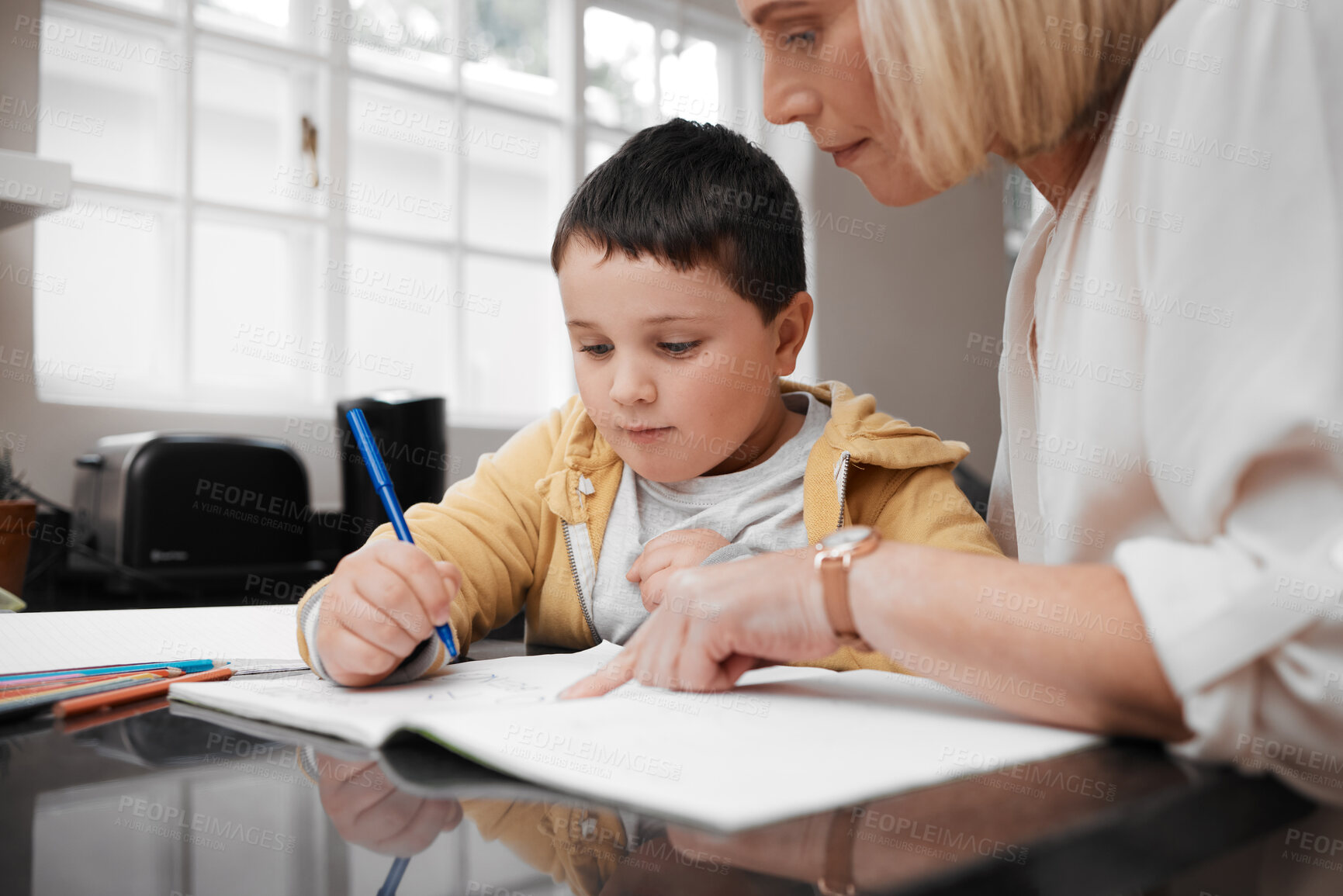 Buy stock photo Shot of a mother and her son completing school work at home