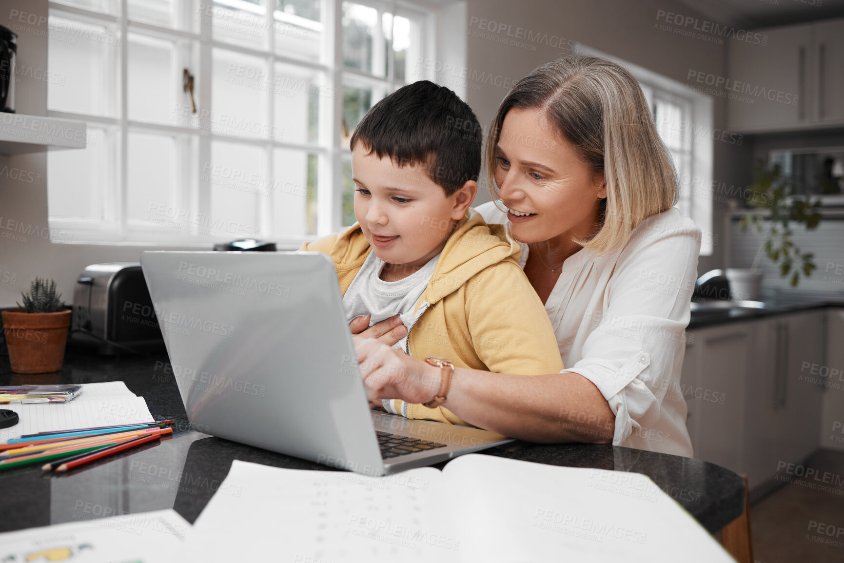 Buy stock photo Shot of a mother and son team using a laptop to complete home schooling work