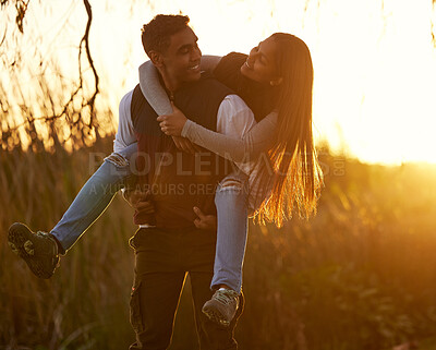 Buy stock photo Shot of a young man giving his girlfriend a piggyback ride