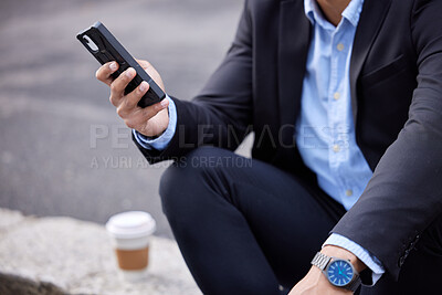 Buy stock photo Cropped shot of an unrecognizable businessman sitting and using his cellphone in the city