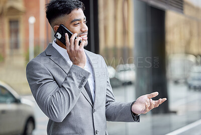 Buy stock photo Shot of a handsome young businessman standing in the city and using his cellphone