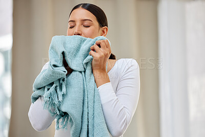 Buy stock photo Shot of a young woman smelling freshly cleaned laundry