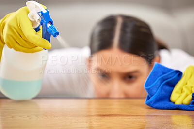 Buy stock photo Shot of a young woman spraying cleaner on her coffee table