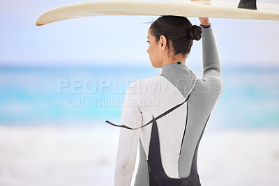 Buy stock photo Shot of a young woman holding a surfboard at the beach