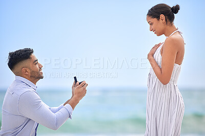 Buy stock photo Engagement, proposal and romance with a couple on the beach for a milestone on a blue sky background. Love, summer or nature with a man down on one knee to ask his girlfriend the marriage question