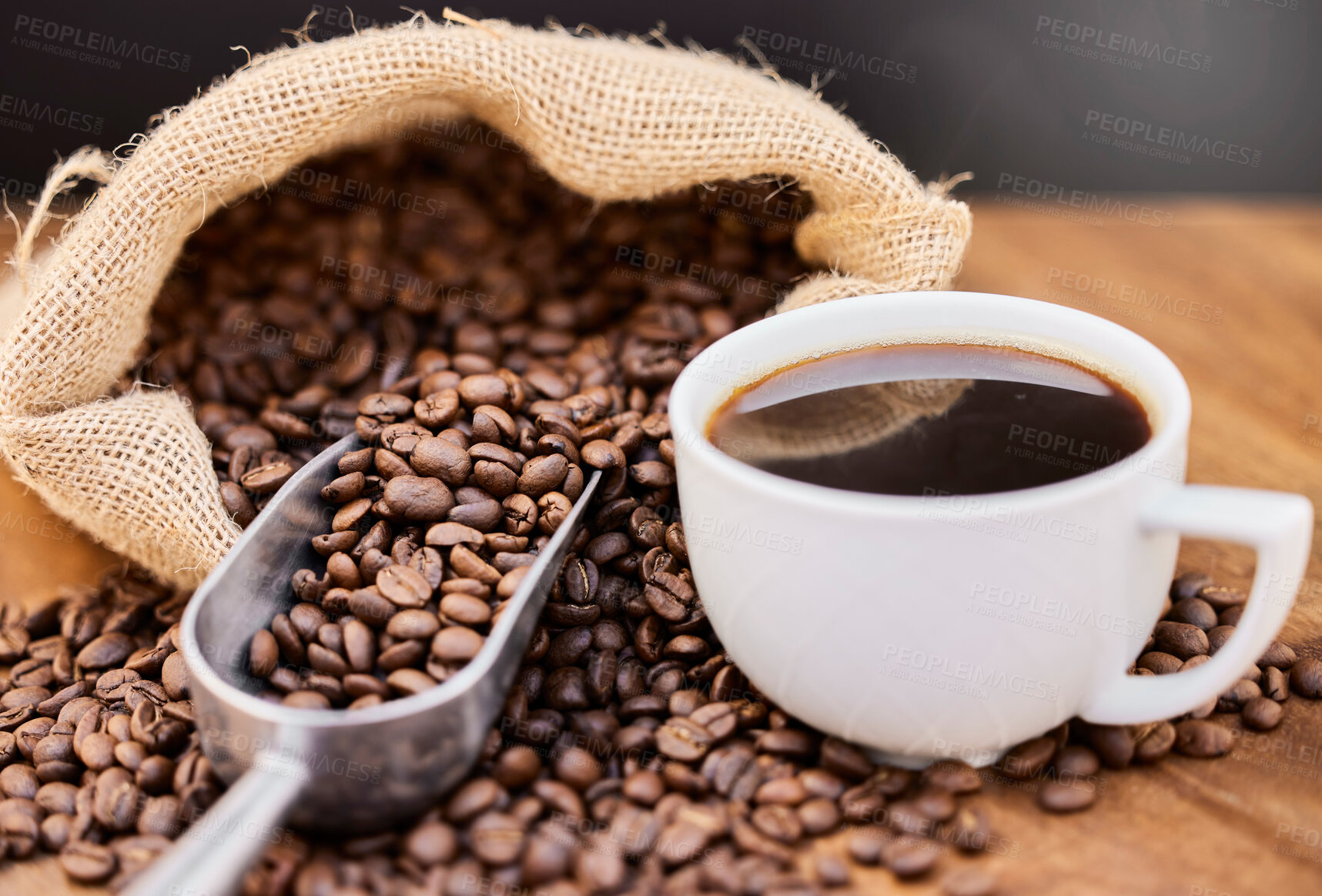 Buy stock photo Shot of coffee beans and a cup of black coffee on a wooden table