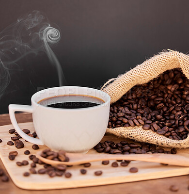 Buy stock photo Shot of coffee beans and a cup of black coffee on a wooden table