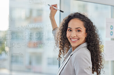 Buy stock photo Portrait of a young businesswoman writing notes on a glass screen in an office
