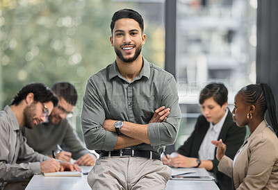 Buy stock photo Portrait of a young businessman at the office sitting in front of his colleagues having a meeting in the background