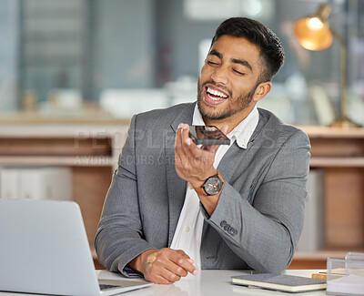 Buy stock photo Shot of a young businessman using a smartphone and laptop in a modern office