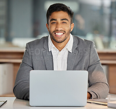 Buy stock photo Shot of a young businessman using a laptop in a modern office
